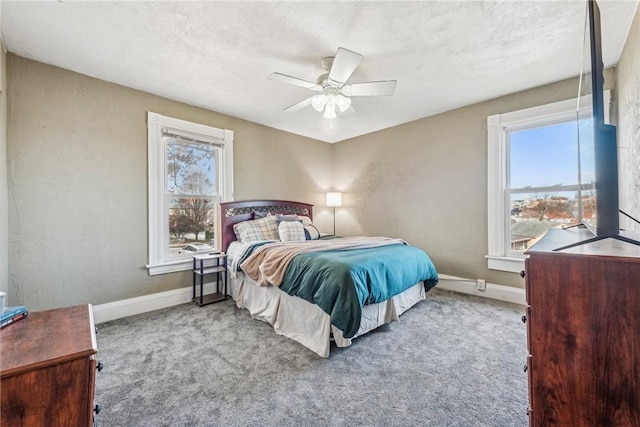 carpeted bedroom with multiple windows and ceiling fan