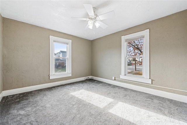 carpeted spare room with ceiling fan