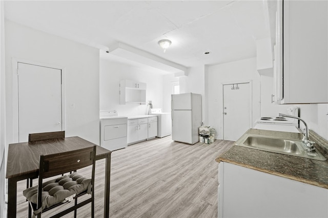 kitchen featuring sink, white fridge, light hardwood / wood-style flooring, and washer / dryer