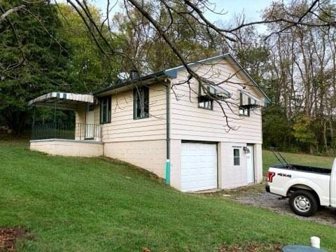 view of property exterior featuring a garage and a yard