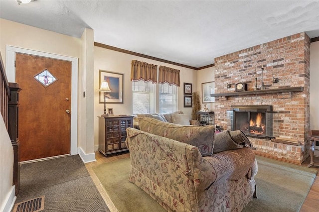 living room with light hardwood / wood-style floors, a brick fireplace, and crown molding