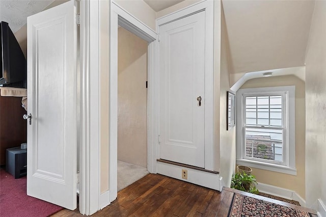 hallway featuring a textured ceiling and dark hardwood / wood-style flooring