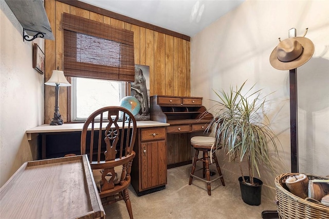 office area with wood walls and light colored carpet