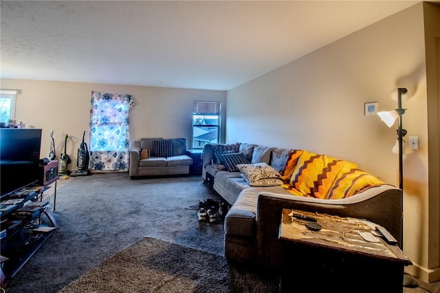 living room with dark colored carpet and a healthy amount of sunlight