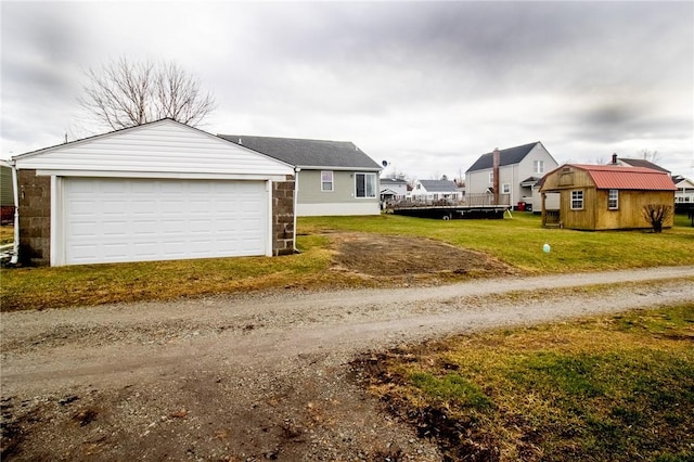 view of side of property featuring an outbuilding, a yard, and a garage