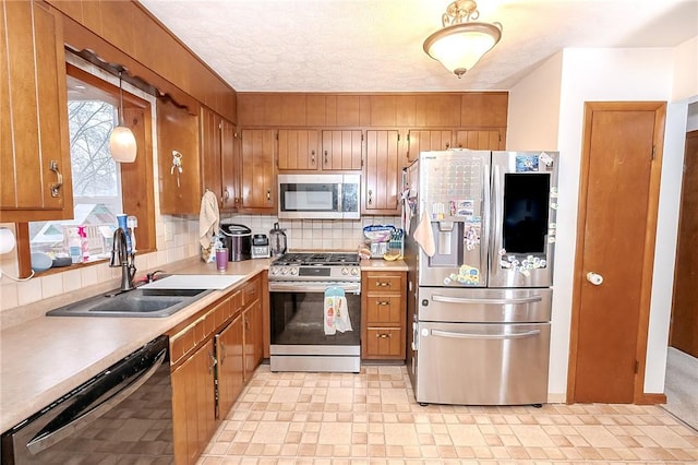 kitchen featuring decorative backsplash, sink, stainless steel appliances, and a textured ceiling