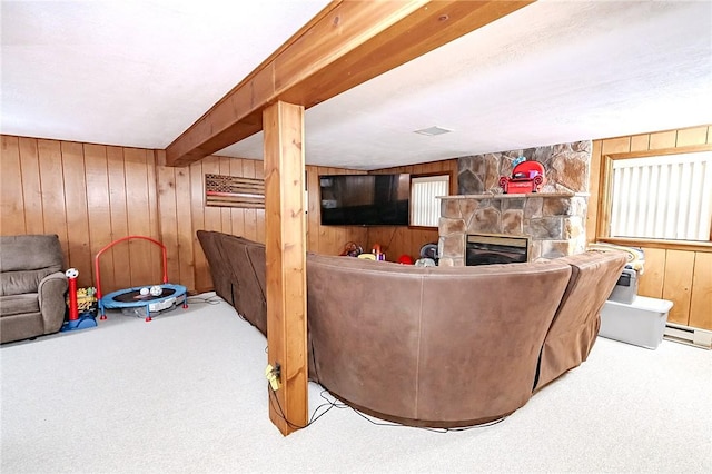 living room with a fireplace, carpet floors, baseboard heating, and wood walls