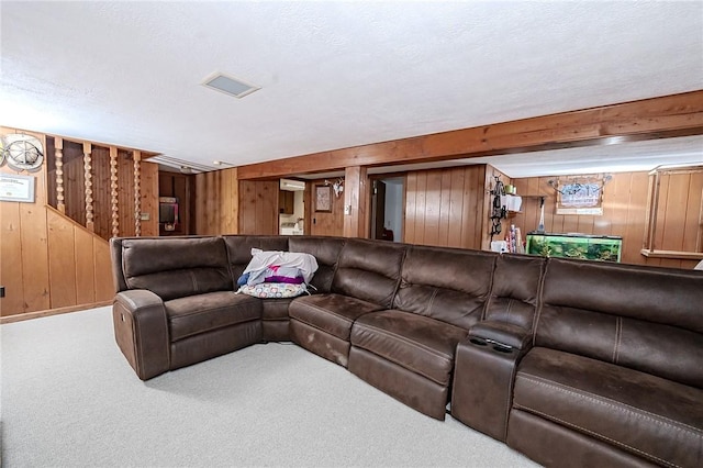 carpeted living room with wood walls