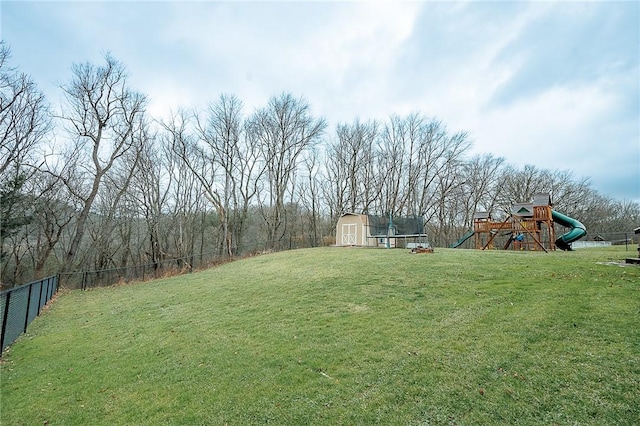 view of yard featuring a trampoline, a playground, and a shed