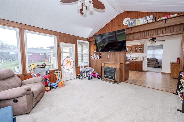 carpeted living room with a fireplace, plenty of natural light, and wooden walls