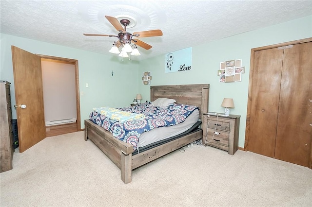 carpeted bedroom with ceiling fan, a baseboard radiator, and a textured ceiling