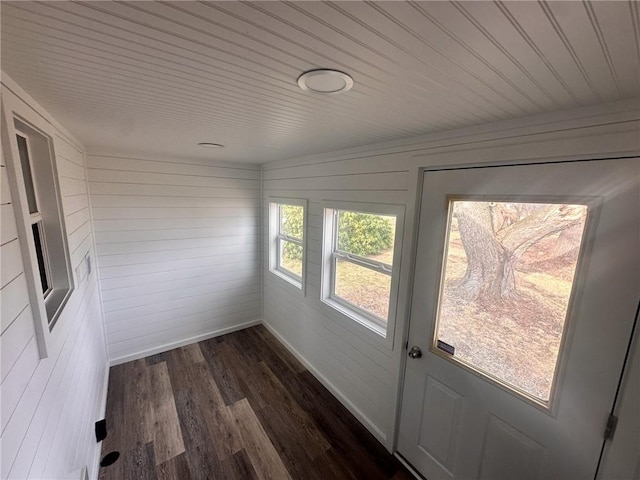 doorway to outside featuring dark hardwood / wood-style flooring and wooden walls