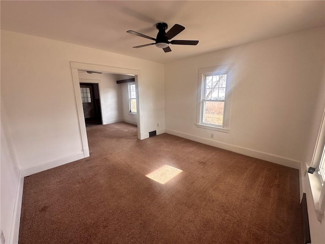 carpeted empty room featuring a wealth of natural light and ceiling fan