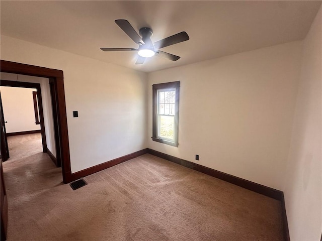 carpeted spare room with ceiling fan