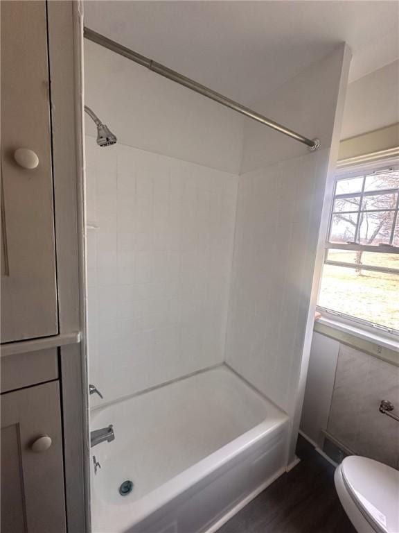 bathroom with plenty of natural light, hardwood / wood-style floors, tub / shower combination, and toilet