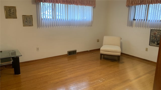 living area with light hardwood / wood-style floors and a healthy amount of sunlight