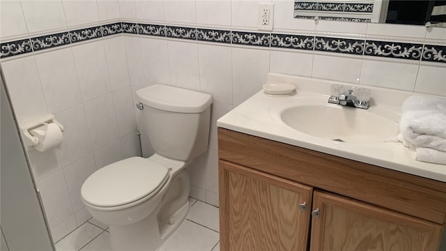 bathroom with tile patterned flooring, vanity, toilet, and tile walls