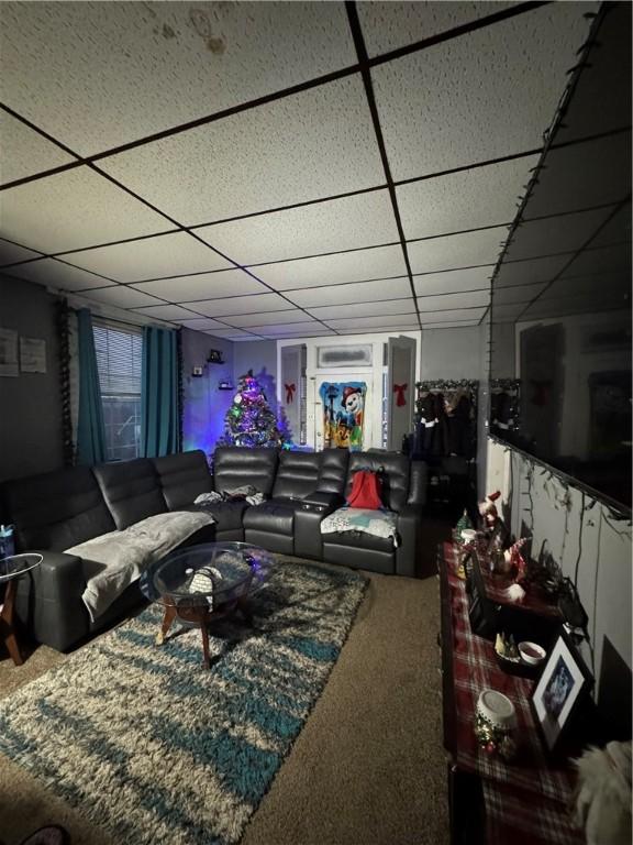 carpeted living room featuring a paneled ceiling