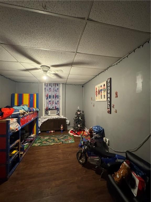 playroom with hardwood / wood-style floors and a drop ceiling