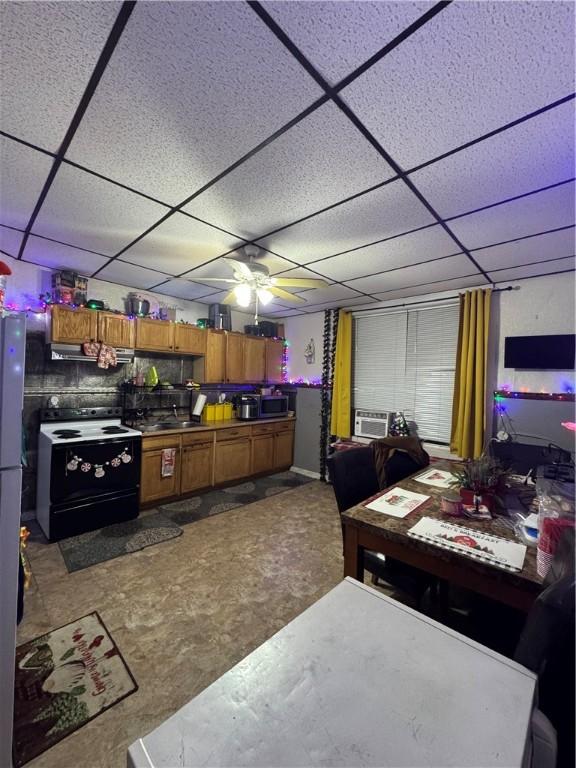 kitchen with a drop ceiling, ceiling fan, sink, electric stove, and range hood