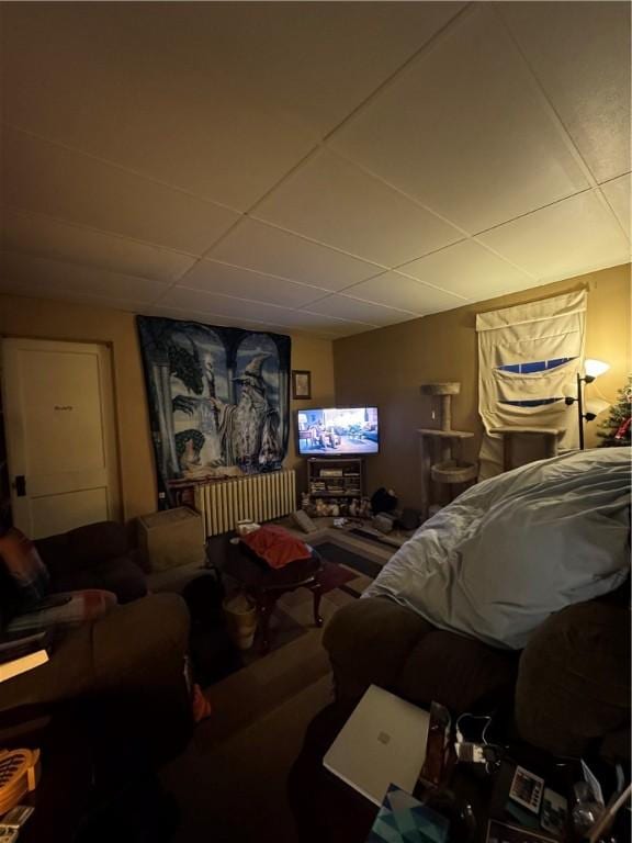 living room featuring a drop ceiling and radiator heating unit