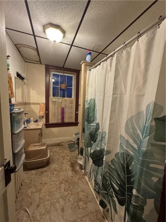 bathroom featuring a drop ceiling and a shower with shower curtain