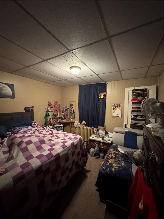 carpeted bedroom with a drop ceiling