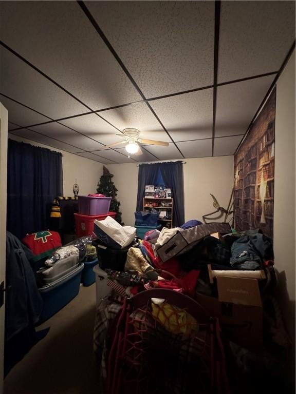 interior space with a paneled ceiling and ceiling fan