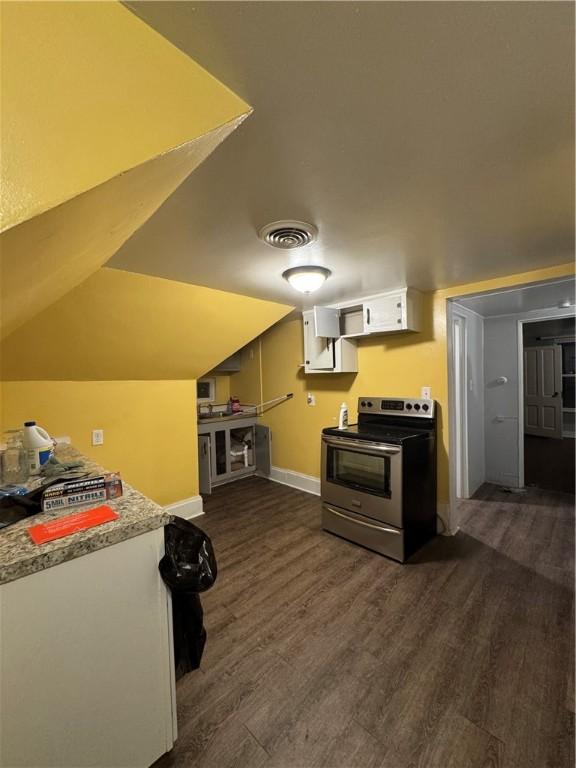 kitchen featuring white cabinets, dark hardwood / wood-style flooring, lofted ceiling, and stainless steel electric range