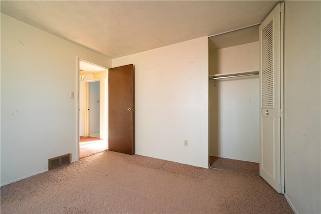 unfurnished bedroom featuring light carpet and a closet