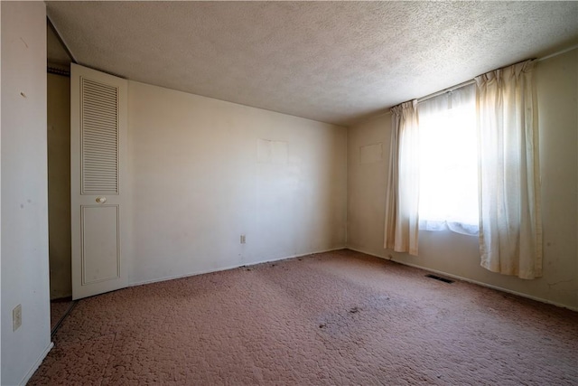 unfurnished bedroom featuring carpet flooring and a textured ceiling