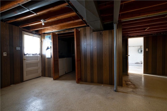 basement with wooden walls and washer and clothes dryer