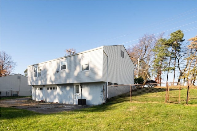 rear view of house with a yard and central AC