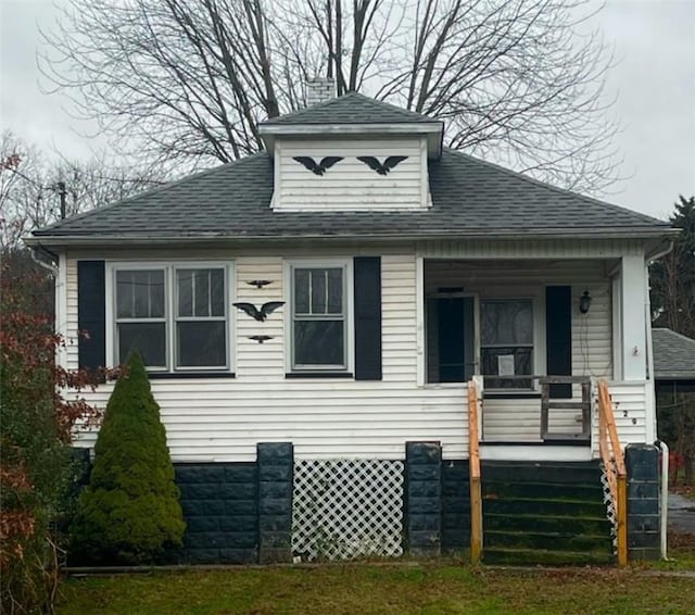 view of side of home with covered porch and a yard