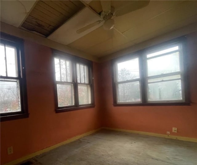 carpeted spare room with a wealth of natural light and ceiling fan