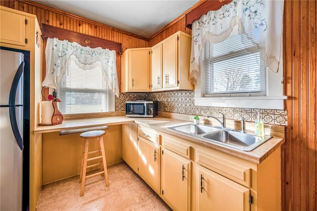 kitchen with decorative backsplash, ornamental molding, stainless steel appliances, sink, and light tile patterned floors