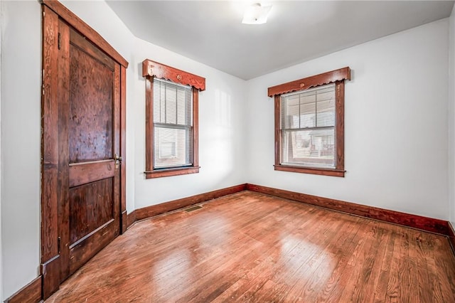 spare room featuring hardwood / wood-style floors and a wealth of natural light