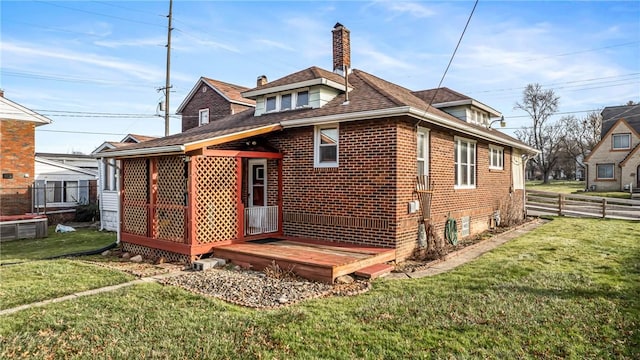 rear view of house featuring a yard