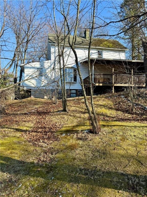 view of side of home featuring a lawn and a wooden deck