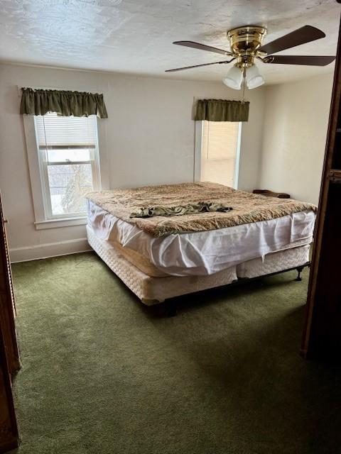 bedroom featuring carpet flooring, ceiling fan, and a textured ceiling