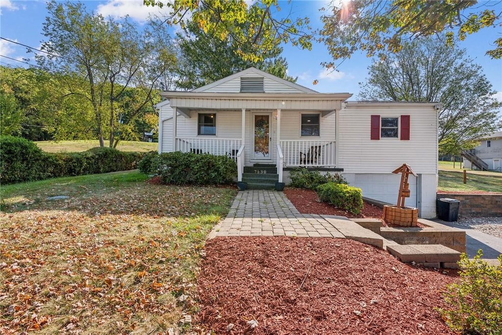 bungalow-style house featuring a garage and a front lawn