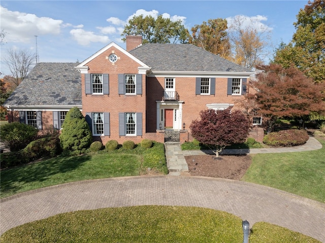 view of front of home featuring a front yard and a balcony