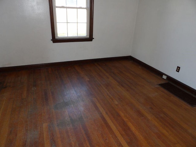 empty room with dark hardwood / wood-style flooring