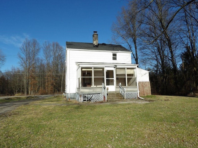 back of house featuring a yard and a sunroom