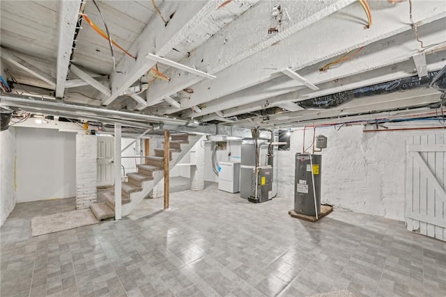 basement featuring electric water heater, heating unit, and washing machine and dryer