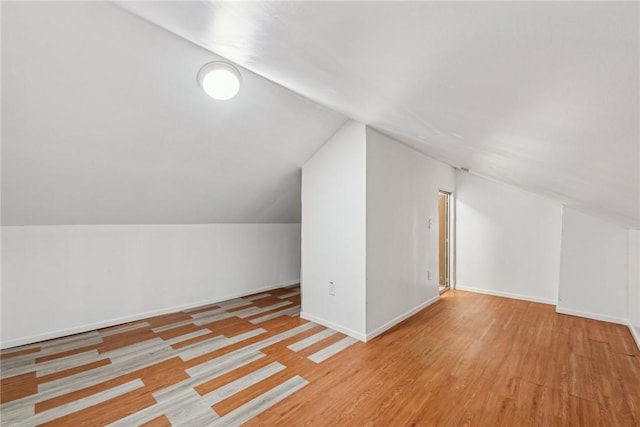 bonus room with vaulted ceiling and light wood-type flooring