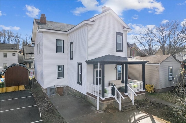 back of house featuring a porch and central AC unit