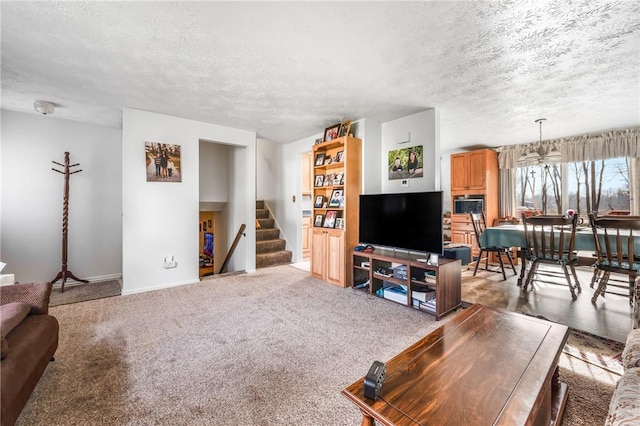 carpeted living room featuring a chandelier and a textured ceiling