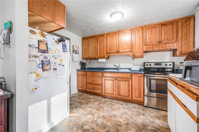 kitchen with a textured ceiling, sink, and stainless steel electric range