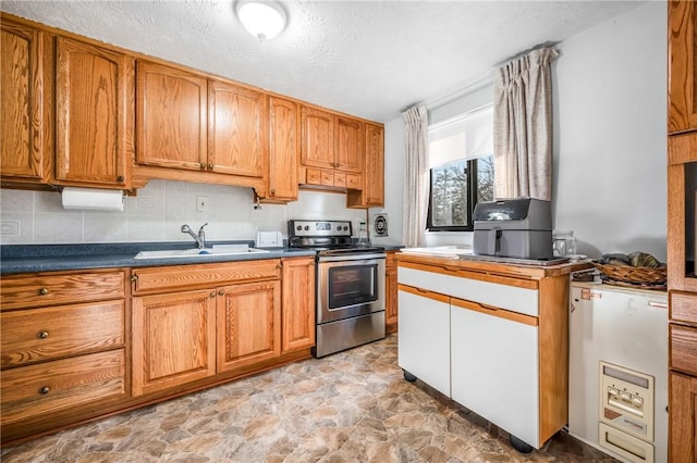 kitchen featuring stainless steel electric stove, a textured ceiling, sink, and tasteful backsplash